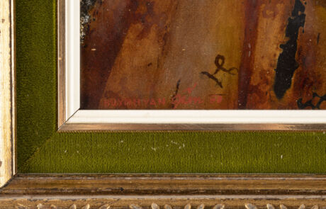 Nahaufnahme eines Teils eines Gemäldes und dessen Bilderrahmen, der in einem Auktionshaus präsentiert wird. Im Vordergrund ist ein grüner Stoffbezug oder eine ähnliche Textur zu sehen, welcher die untere Kante des Rahmens säumt. Der Bilderrahmen selbst ist aus Holz mit goldenen Verzierungen.