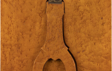 Nahaufnahme eines alten, rostigen Werkzeugs, vermutlich eine Zange oder ein ähnliches Handwerkzeug, auf einem einheitlich orange-braun gemusterten Untergrund. Das Tool zeigt deutliche Gebrauchsspuren und Patina, was auf sein Alter und seine Verwendung hinweist.