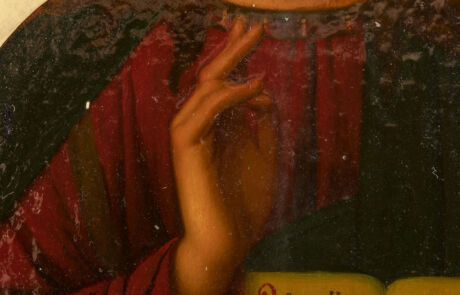 Detailaufnahme eines Gemäldes, das die Hand einer Figur zeigt, die eine spezifische Geste macht. Die Hand ist teilweise erhoben mit gespreizten Fingern. Sie ist gekleidet in einen scharlachroten Umhang mit sichtbaren Falten und Textur, welcher einen dramatischen und lebendigen Eindruck vermittelt.