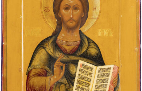 Gemälde einer Ikone, die Jesus Christus darstellt, abgebildet mit einem goldenen Heiligenschein. Jesus trägt traditionelle Gewänder und hält ein offenes Buch mit kyrillischen Schriftzeichen. Seine rechte Hand ist in einer Segensgeste erhoben. Der Hintergrund ist in einem leuchtenden Orange-Ton gehalten.