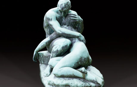 Alt-Text: Skulptur, die ein Paar darstellt, von Auguste Rodin, bekannt als "Der Kuss". Die Skulptur zeigt zwei nackte Figuren in einer innigen Umarmung und Kussposition, sitzend auf einem Felsen. Das Kunstwerk ist durch seine feinen Details und die emotionale Darstellung der menschlichen Figur charakterisiert und stammt aus der französischen Bildhauerkunst.