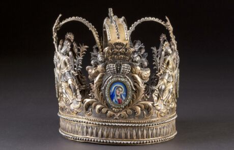 Detaillierte historische Krone mit Ornamenten und einem zentralen Medaillonbild bei einer Kunstauktion.