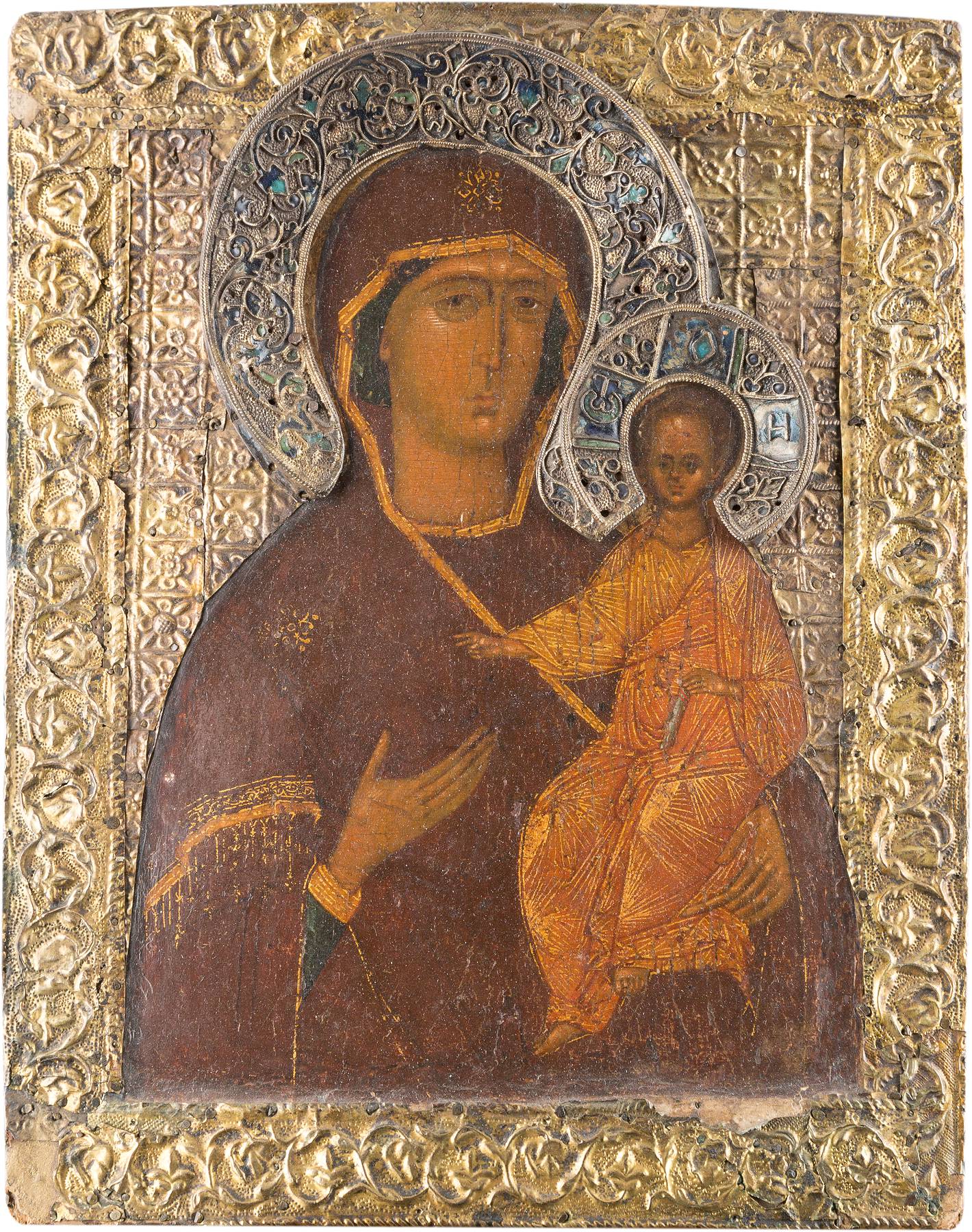 Verzierte Ikone mit Darstellung der Muttergottes mit Kind, umgeben von reichem Metallrahmen mit filigranen Mustern und Edelsteinen.