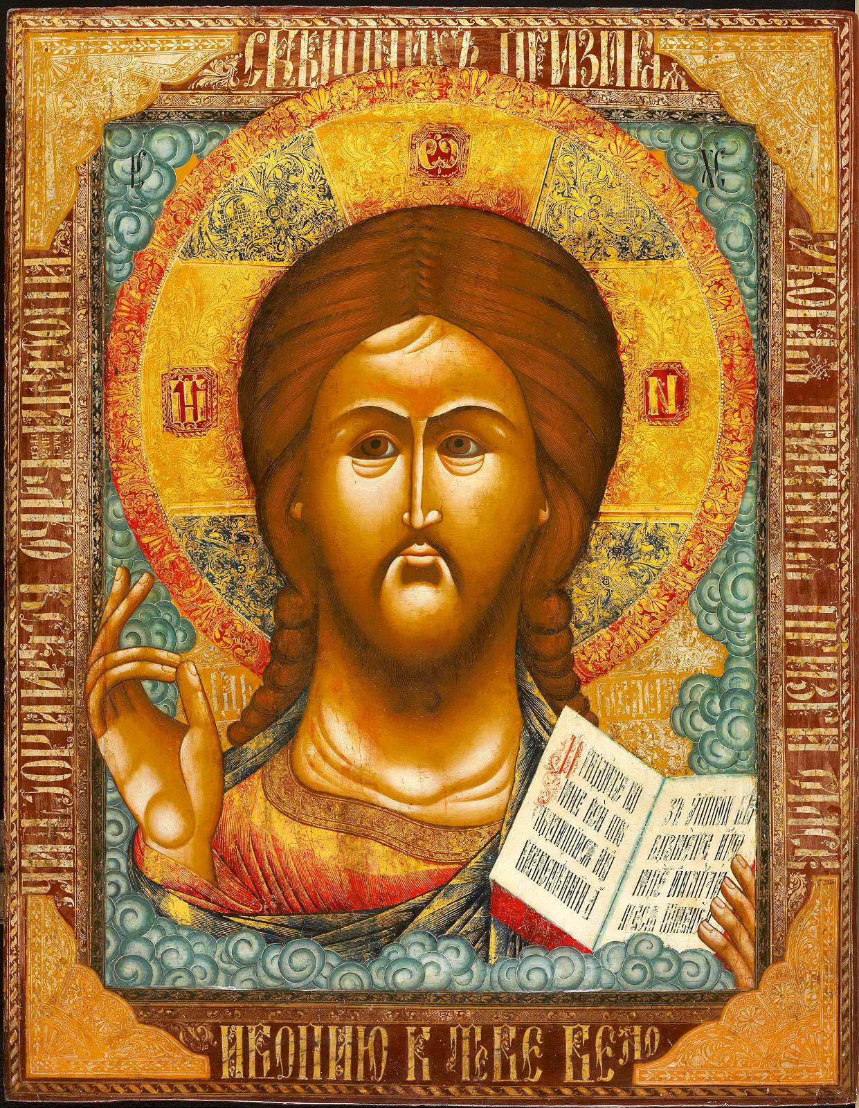 Detailreich gestaltetes Ikone von Jesus Christus mit Segensgeste und Heiliger Schrift, umrandet von kunstvollen Mustern.