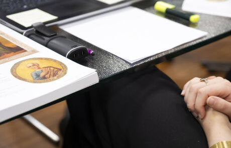 Detailaufnahme eines Auktionstisches bei Hargesheimer mit Kunstauktionskatalog und gefalteten Händen einer Person.