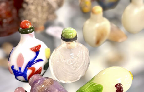 Verschiedene handgefertigte Glasflakons, kunstvoll gestaltet, als Sammlerstücke in einer Kunstauktion präsentiert.